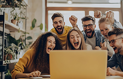 Group celebrating around a laptop